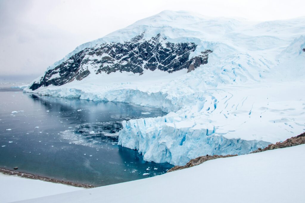 Travelers stepping off a Zodiac onto the Antarctic mainland at Neko Harbour.