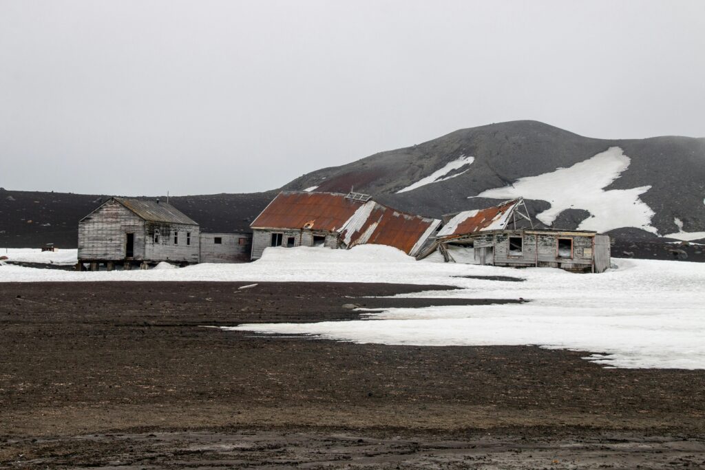 Expedition ship in the volcanic crater of Deception Island with black sand beaches.