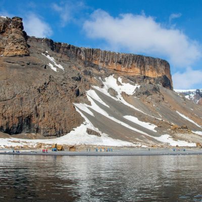 Rust-colored cliffs and Adélie Penguins at Brown Bluff.